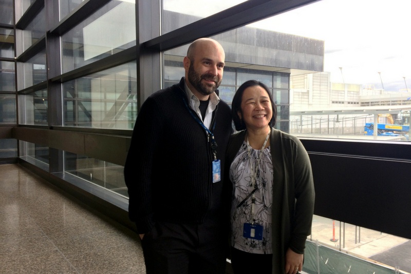 A man and woman posing for a photo in an airport.