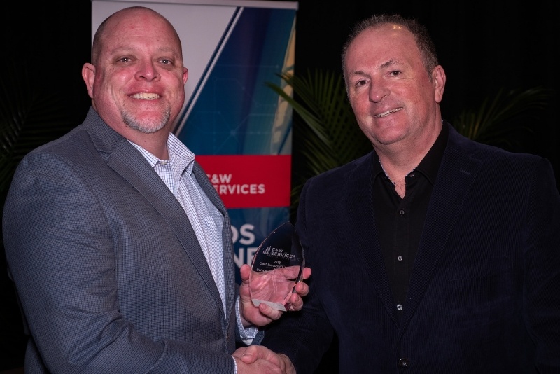 Chris Johnson accepts his Chief Executive Award at C&W Services' leadership meeting.