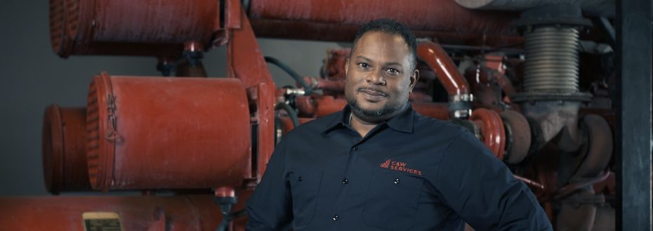 A man standing in front of a red machine.