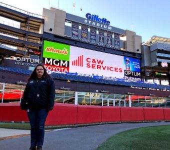 Melissa, facility services intern, stands on the field at Gillette Stadium.