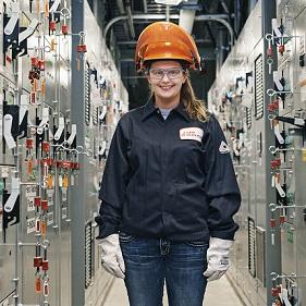 A woman standing in a room full of electrical equipment.