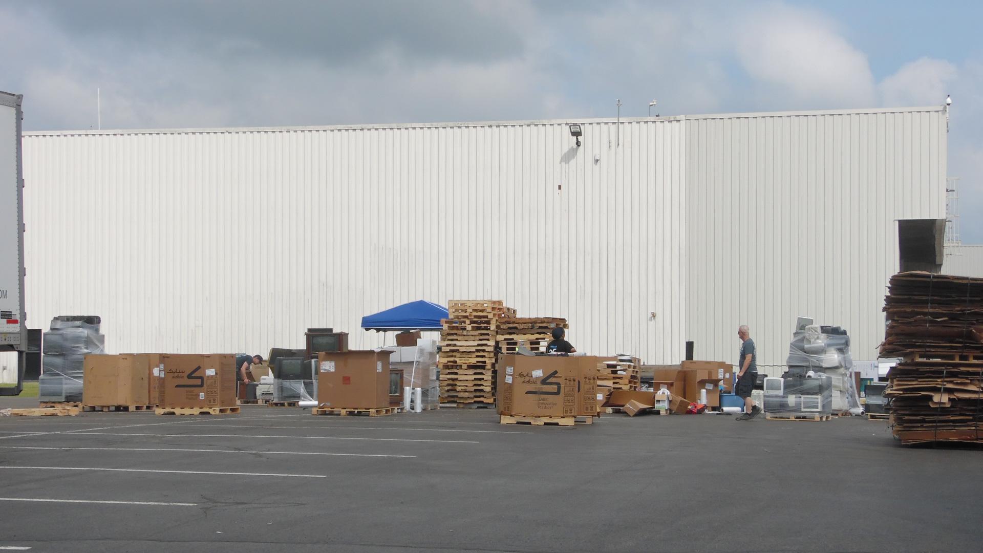 Pallets and boxes of difficult-to-recycle materials are collected and organized in the Cummins parking lot