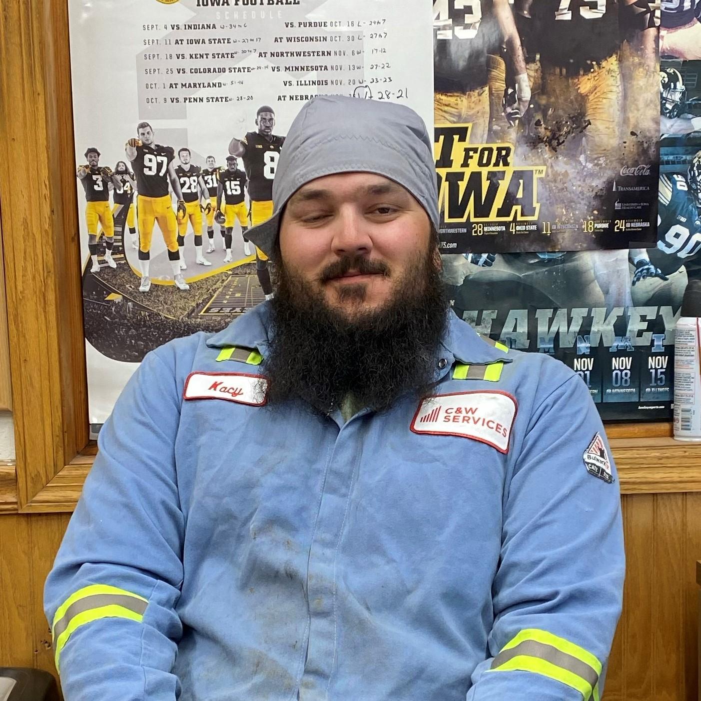 A man with a beard sitting in front of a desk.