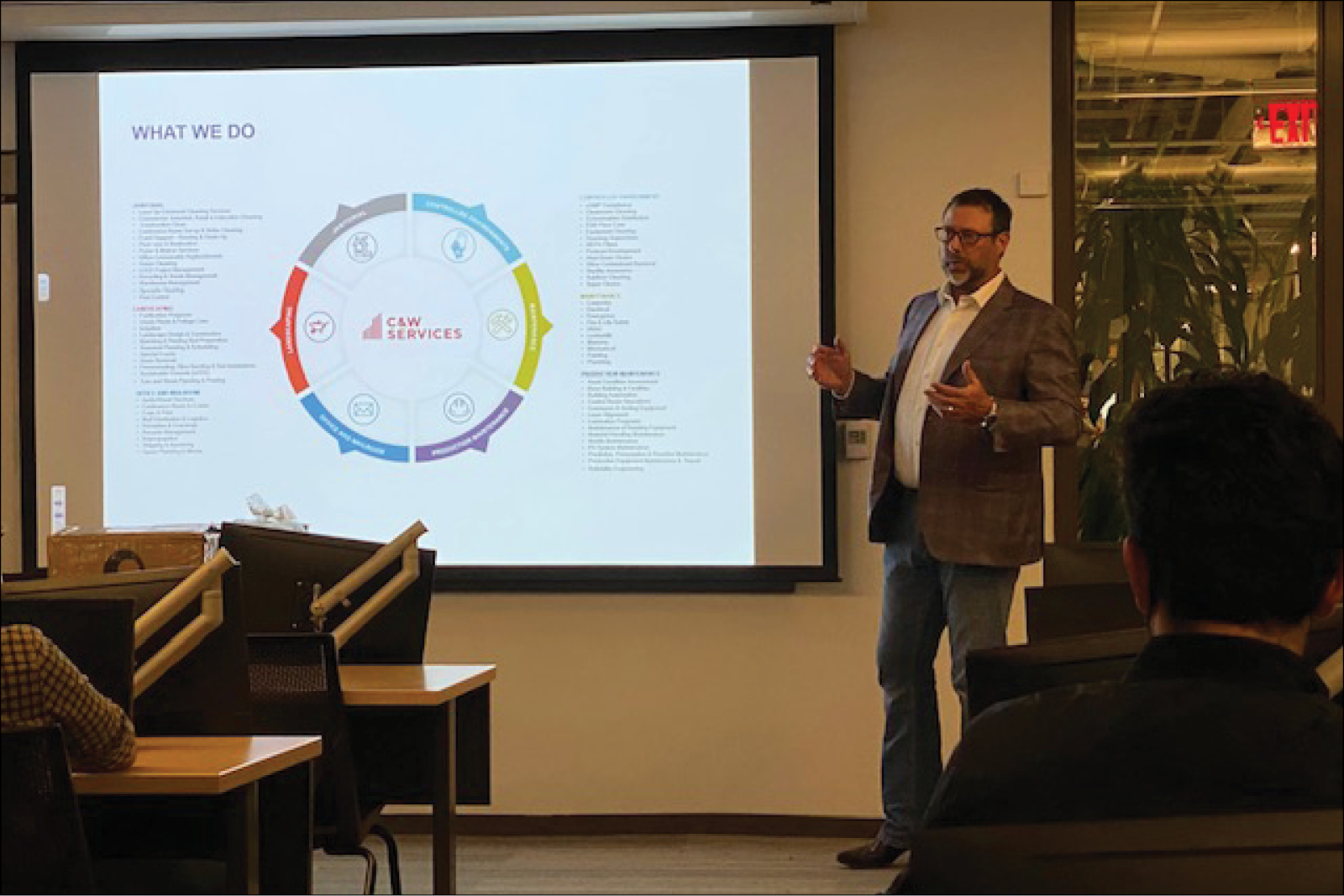 A man giving a presentation in front of a screen.