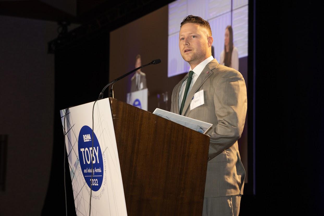 A man in a suit standing at a podium.