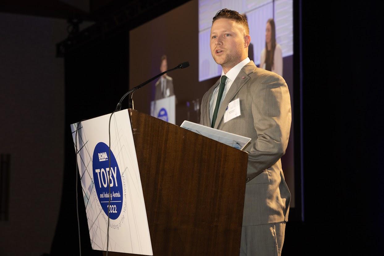 A man in a suit standing at a podium.