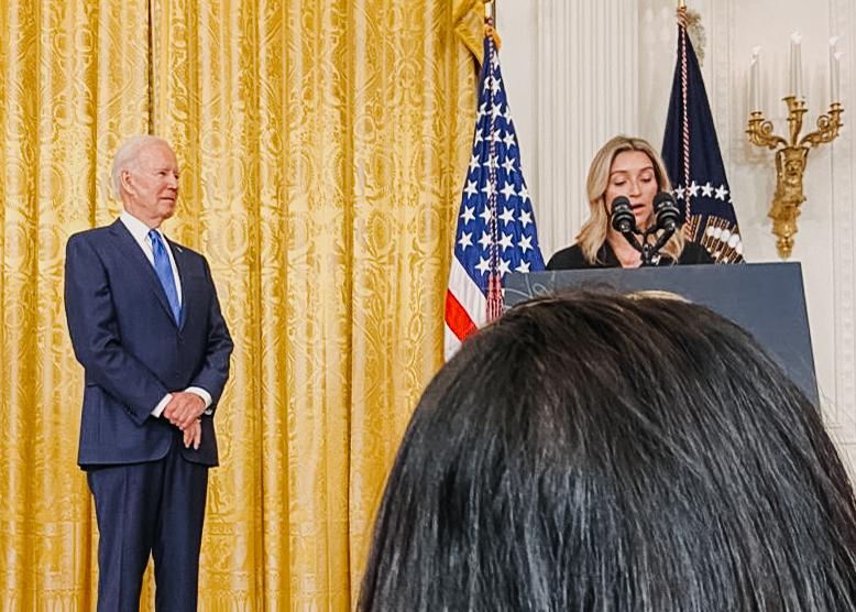 A woman standing at a podium next to a man.