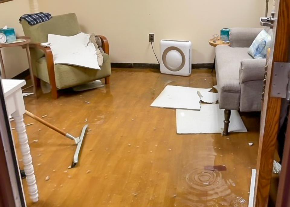 A flooded room with a couch and a chair.