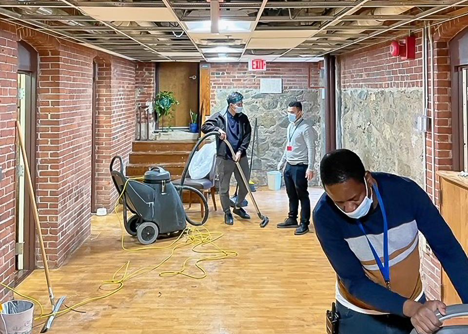 A group of people working on a floor in a building.