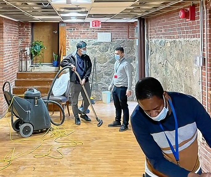 A group of people working on a floor in a building.