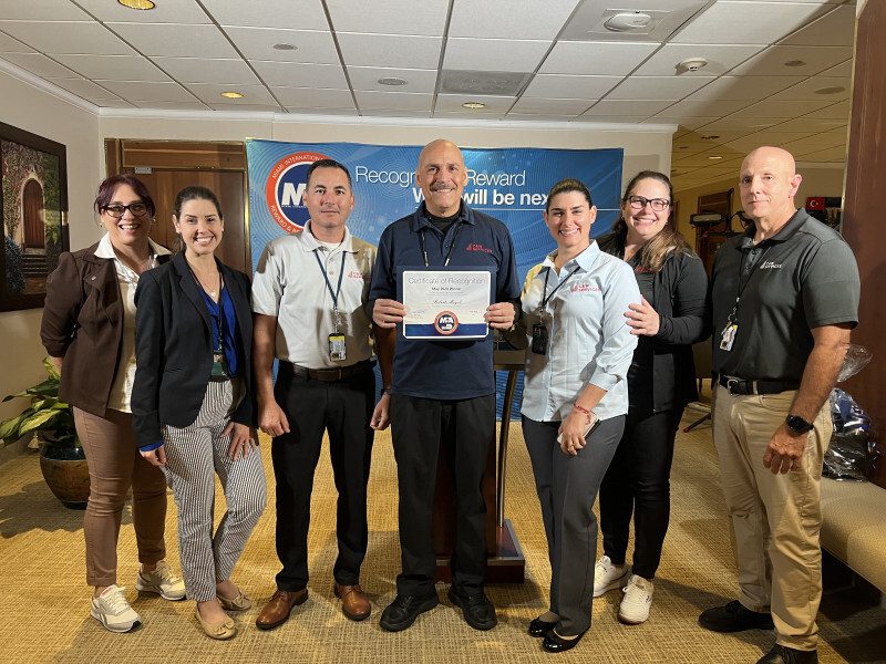 A group of people posing for a picture with a certificate.