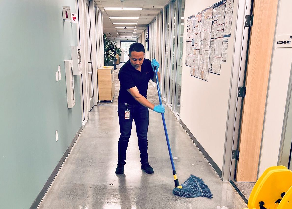 A man holding a mop in a hallway