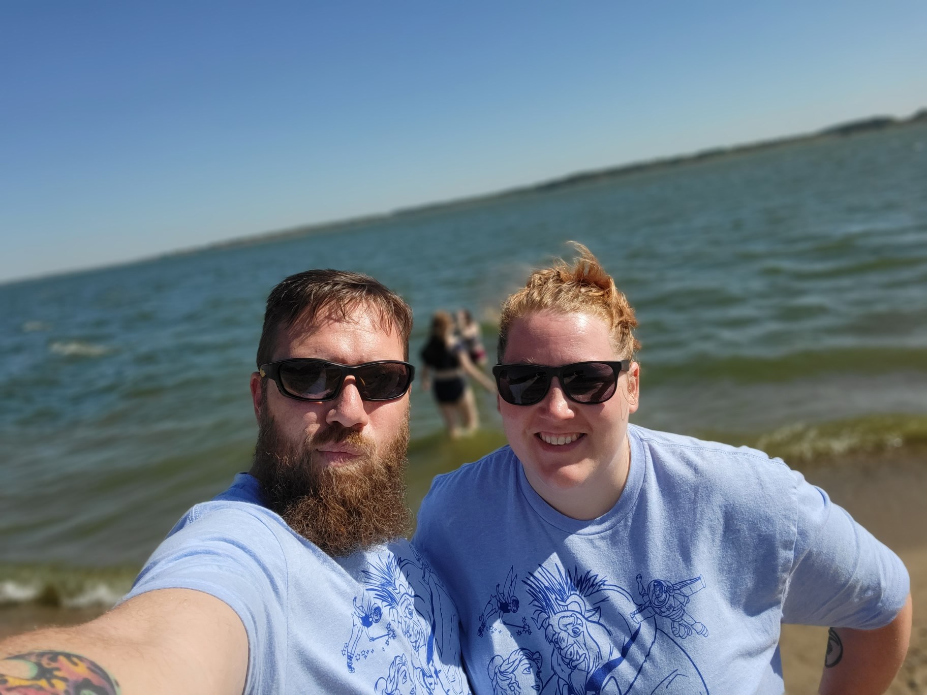 A man and womantaking a selfie in front of water
