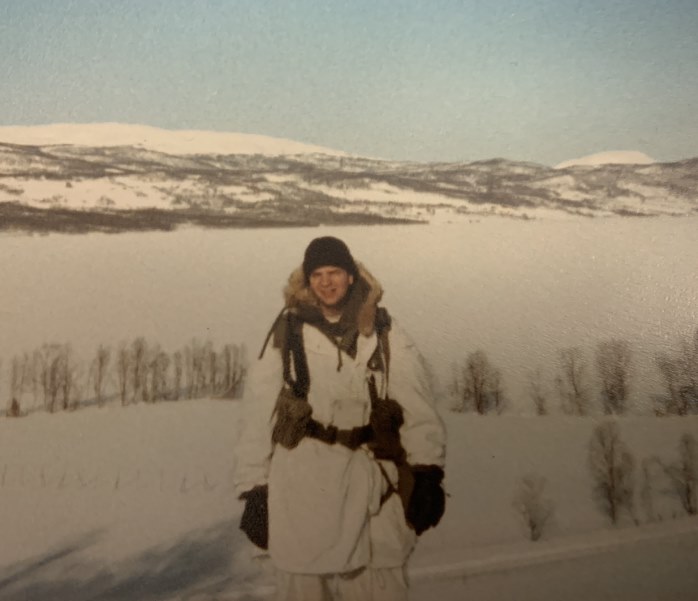 A man in a white coat in a snowy landscape