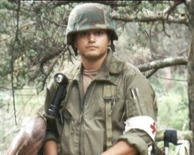 A man in a military uniform standing in a woods