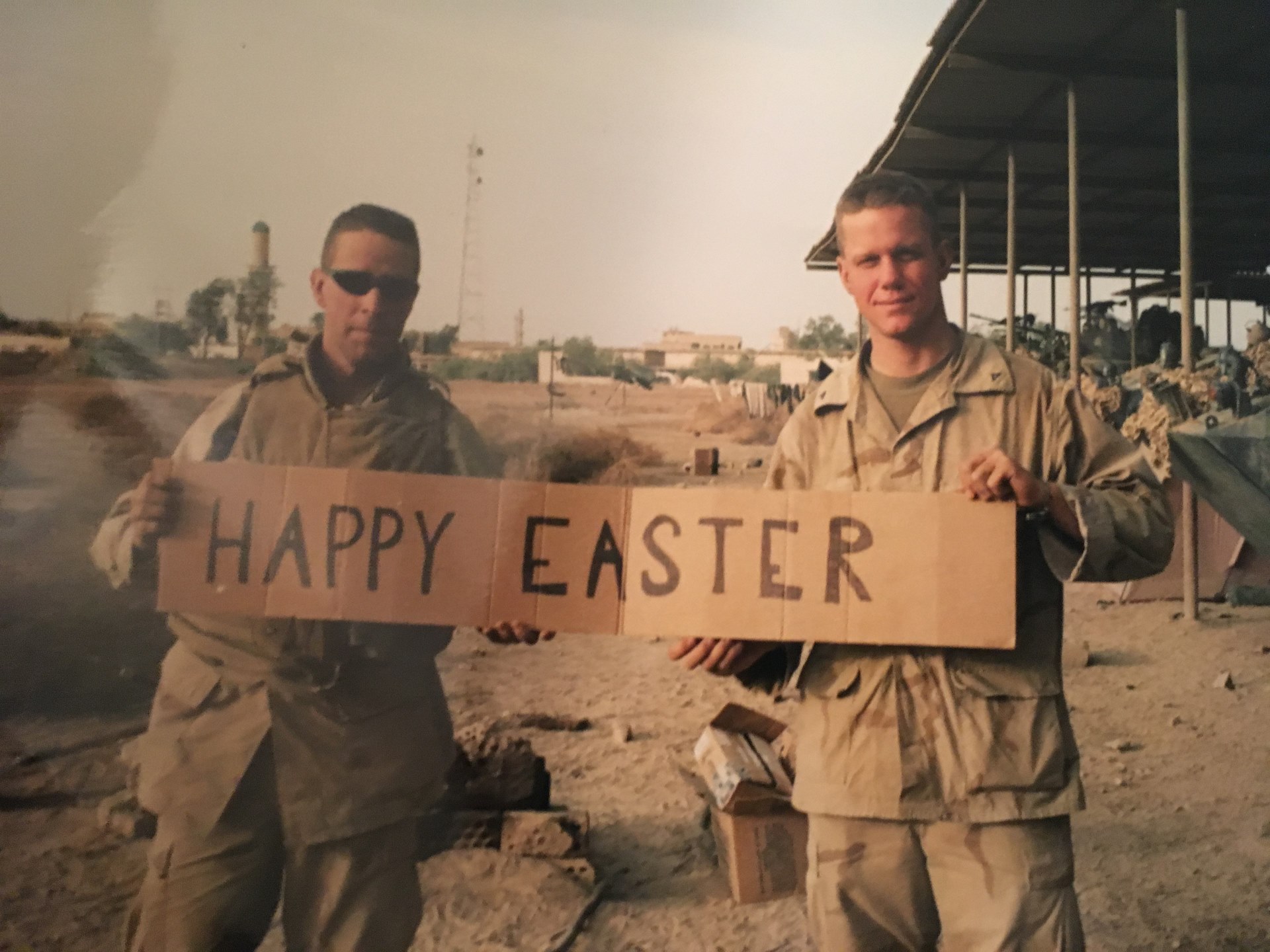 Two men in military uniform holding a "Happy Easter" sign