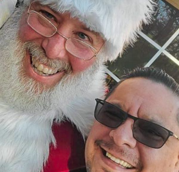 Juan Gomez and a volunteer pose with Santa