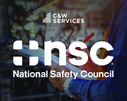 A person in a safety vest writes on a clipboard. The image features the logos of C&W Services and the National Safety Council.