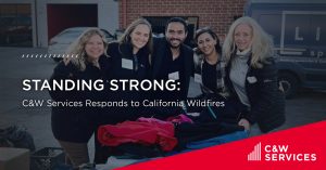 Group of five people smiling while organizing supplies outdoors, with the text "Standing Strong: C&W Services Responds to California Wildfires" overlaid.