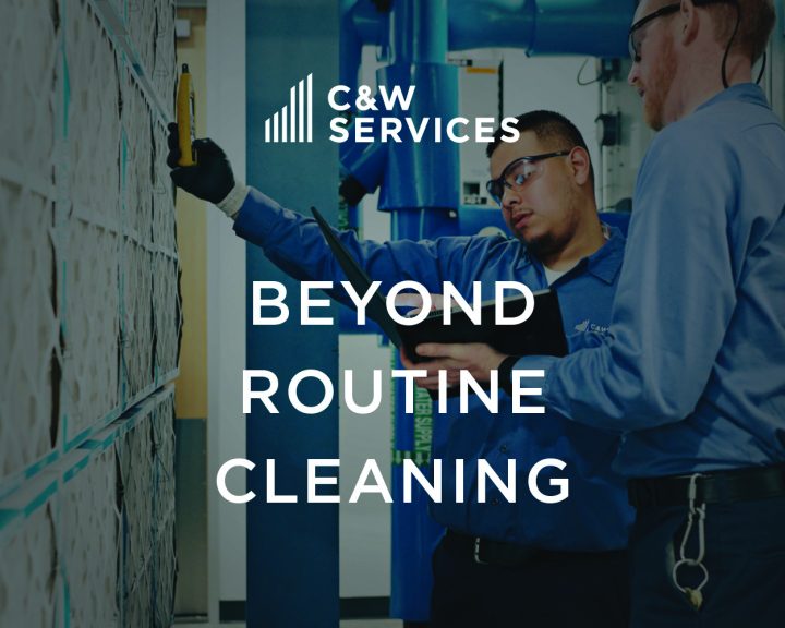 Two workers in uniforms inspect wall panels with tools in a facility. Text overlay reads, 
