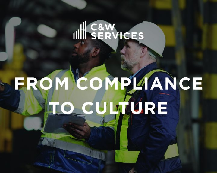 Two workers in safety gear discuss in an industrial setting with the text 
