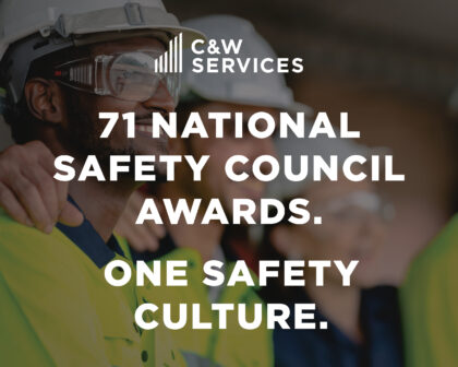 A group of people in safety gear stands together, with text overlay: 